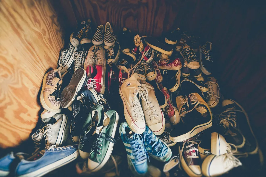 Tumpukan sneakers canvas dan kanvas bekas